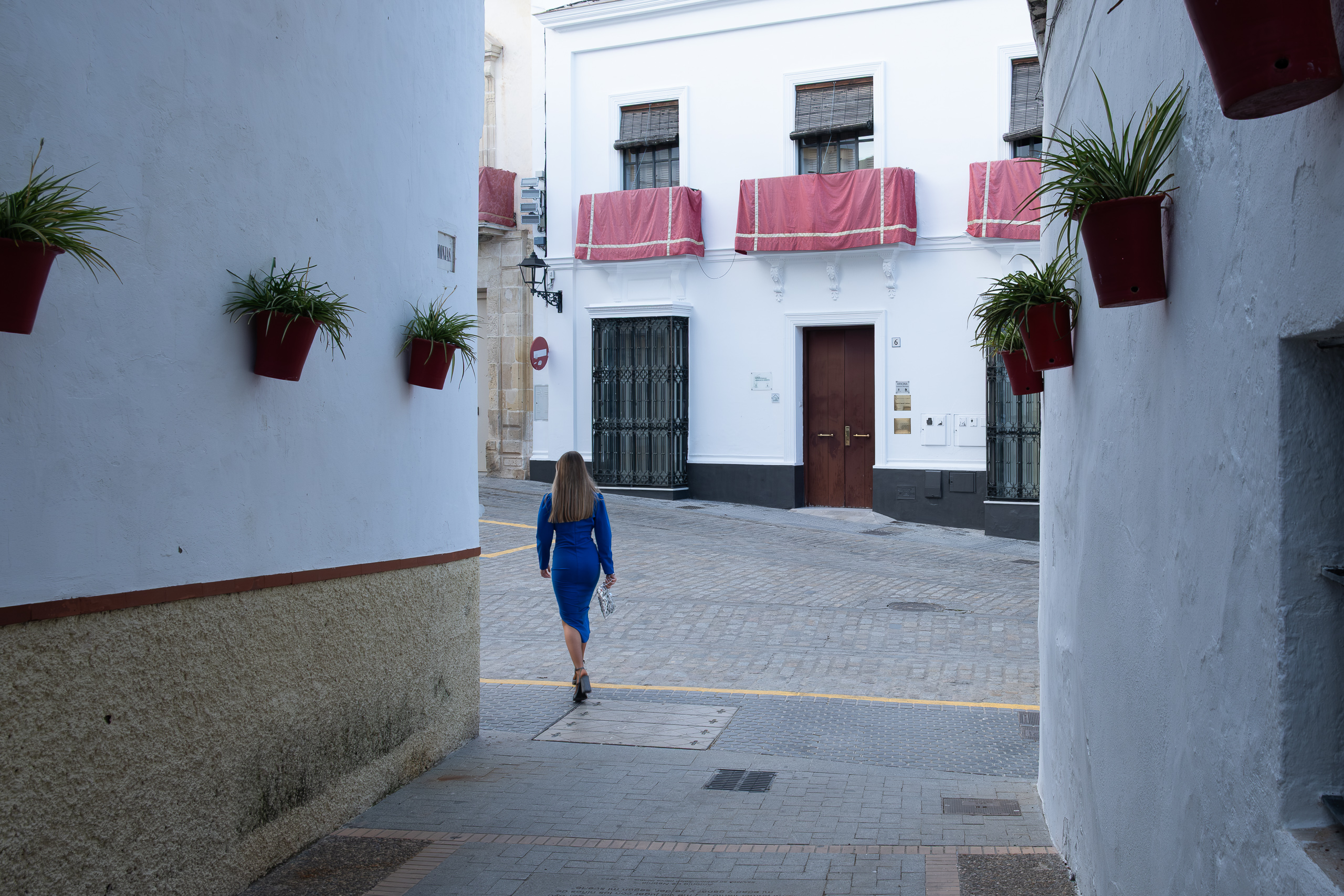 Eine Frau in Blau durchquert die stille Gasse